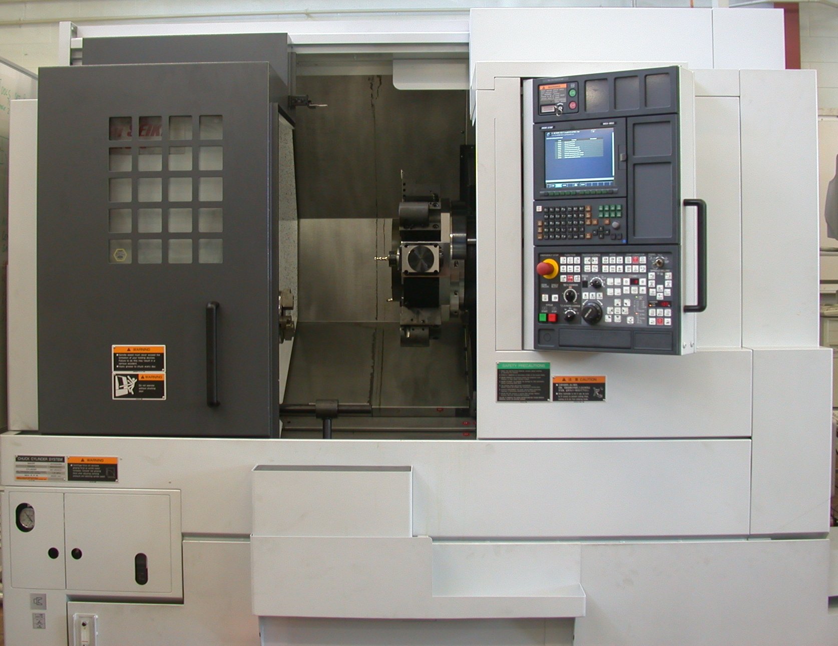 Mori Seiki CNC lathe with open work area, tooling, and operator control panel in a machine shop