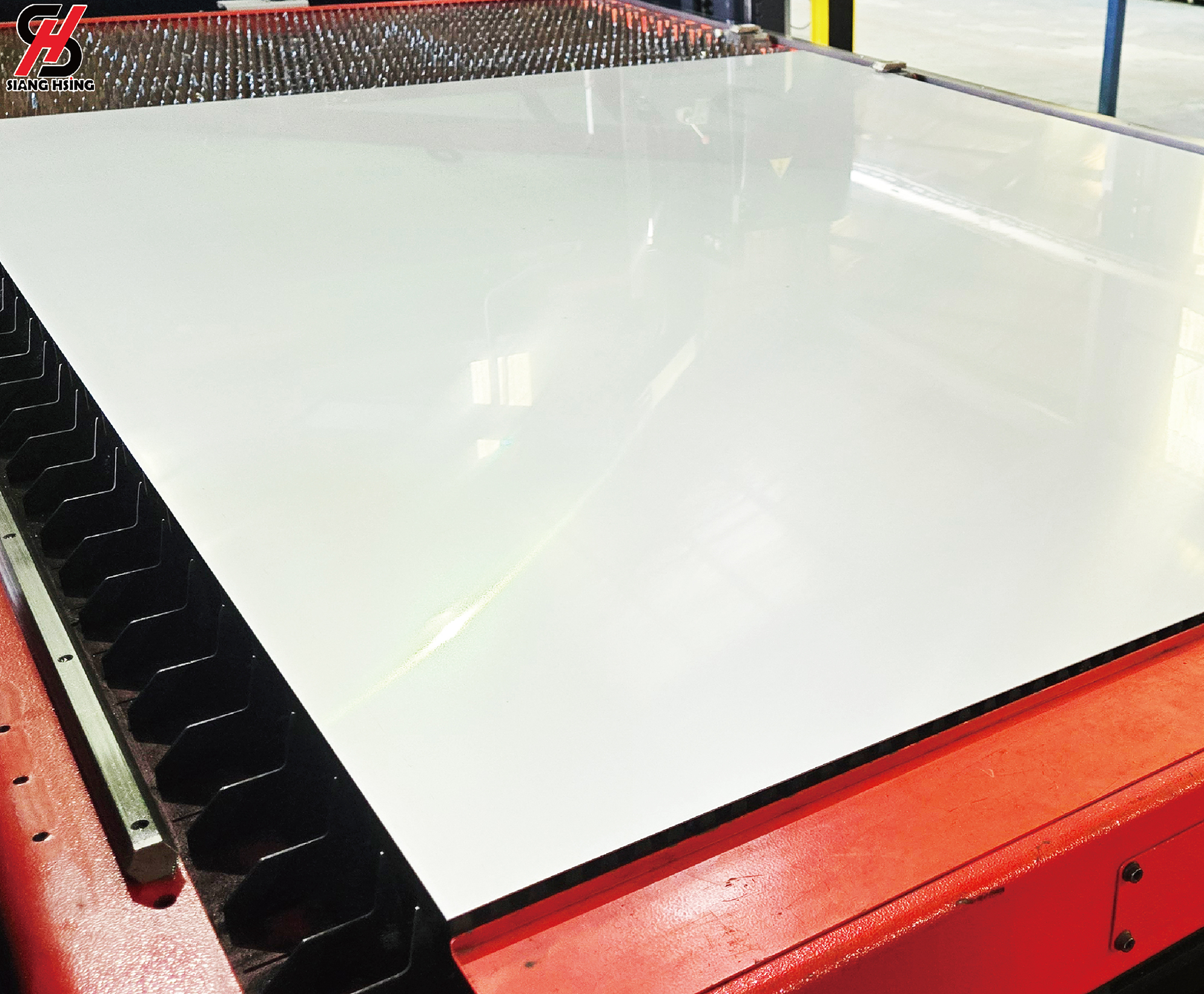 Sheet metal incoming quality-control inspection photograph showing a large reflective metal sheet on a factory inspection table