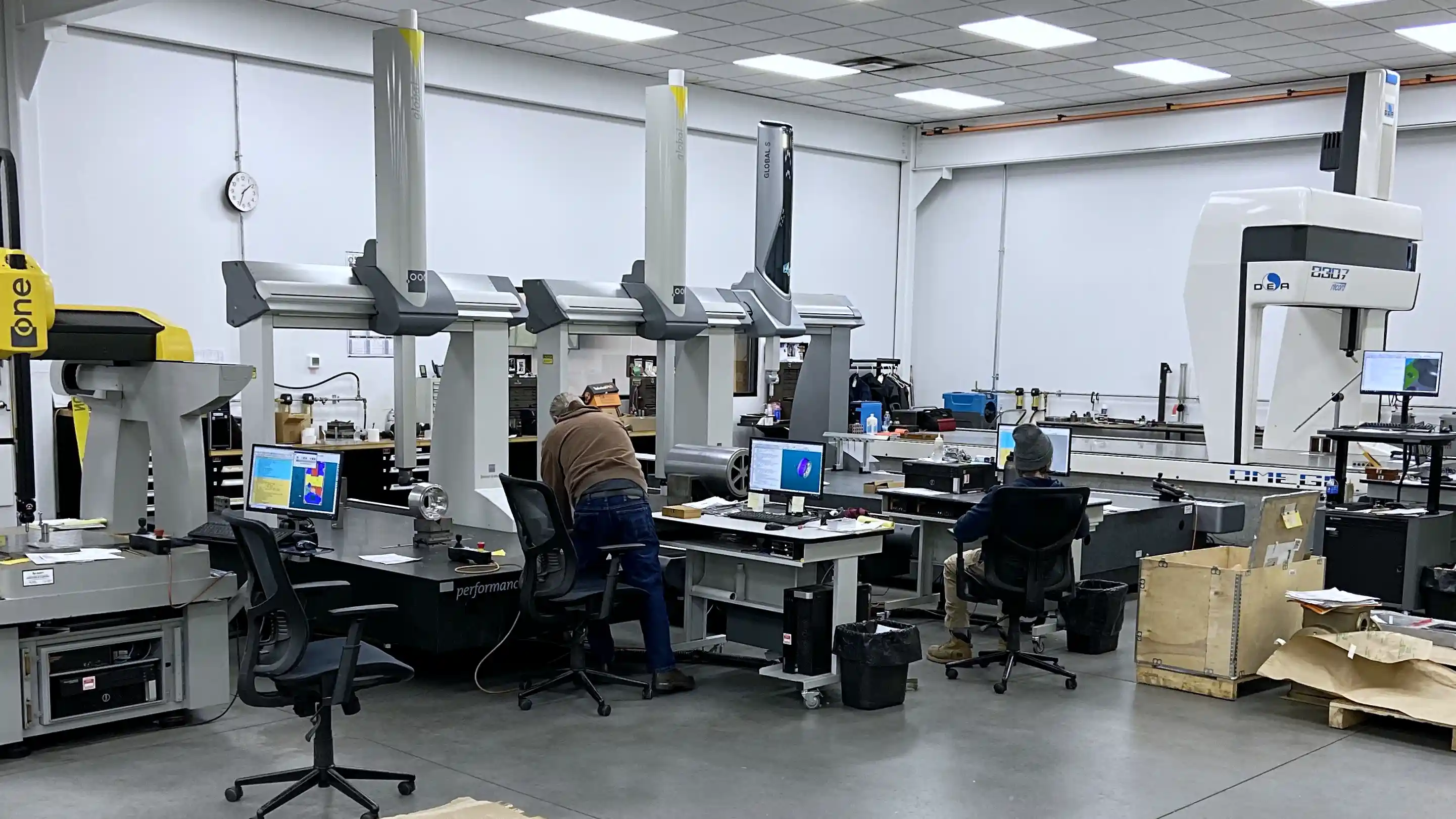 CMM inspection lab with machined metal parts and measurement equipment in a manufacturing quality department