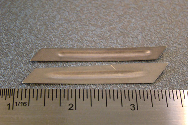 Precision stamped metal shims and seals displayed as photographed products on an industrial manufacturer page