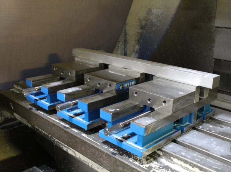Vise-style CNC fixture securing a machined workpiece for repeatable manufacturing operations