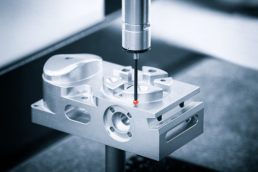 Coordinate measuring machine inspecting a precision metal part during fit verification