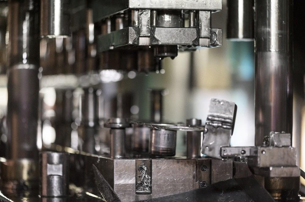 Close-up hydraulic press stamping machine forming sheet metal inside an industrial manufacturing die