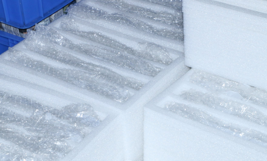 Packaged CNC machined metal parts arranged in protective plastic netting for shipment