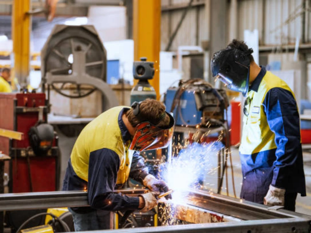Fabricator welding a custom metal assembly